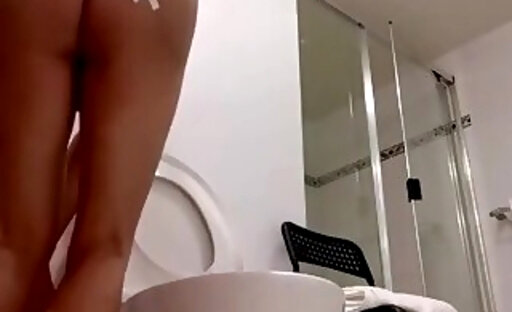 Busty shemale doing chores in the bathroom naked