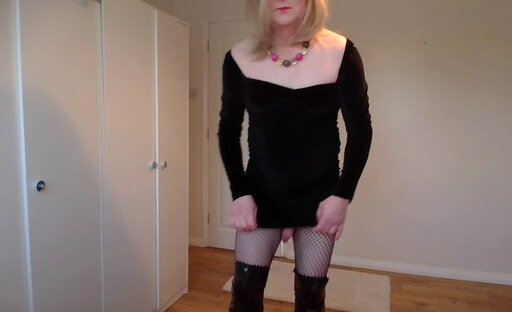 Blonde in a little black dress, boots and fishnets