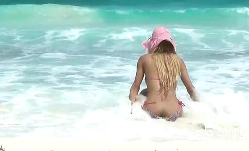 Karla Carrillo in the pink hat on the beach
