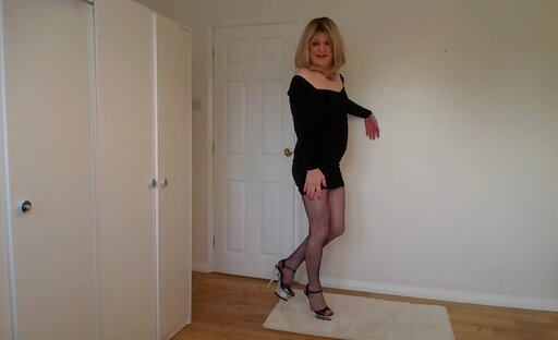 Cute blonde in little black dress, fishnets and heels
